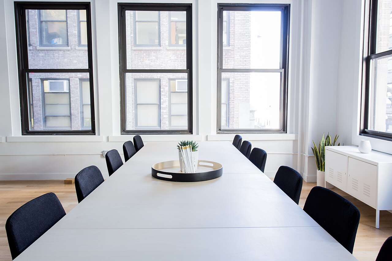 Sala de reuniones moderna con mesa de trabajo y sillas, preparada para atender una consulta